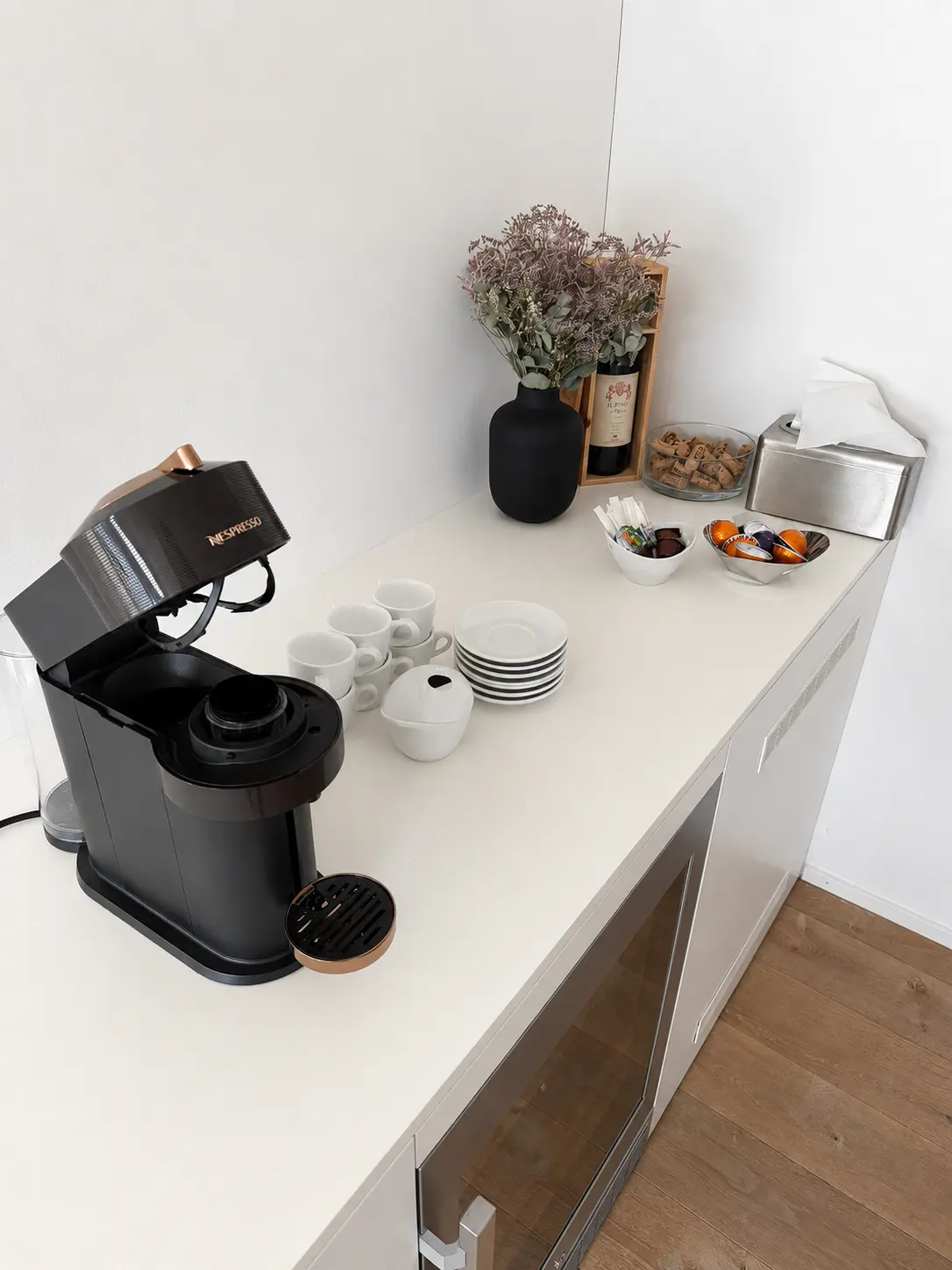 Kaffeestation mit Nespresso-Maschine, Geschirr und Snacks